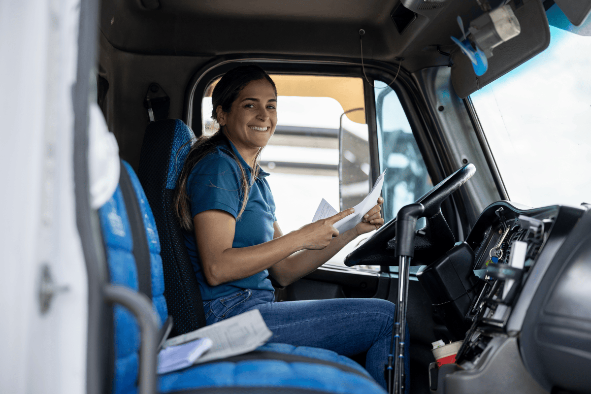 Owner-operator in her truck cab reviewing a payment