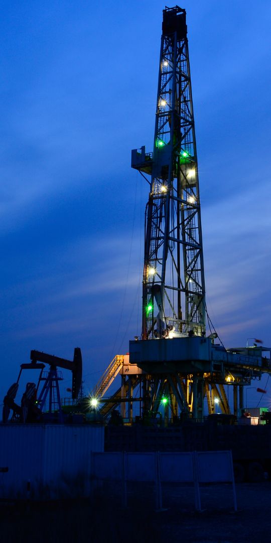 Drilling rig lit at dusk