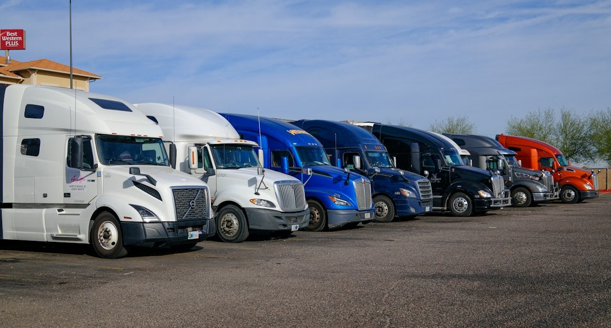 Several semi trucks parked in a row at a terminal